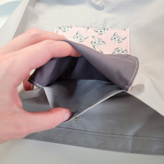 Inside of the foldable tote bag, a hidden pocket underneath the flap.