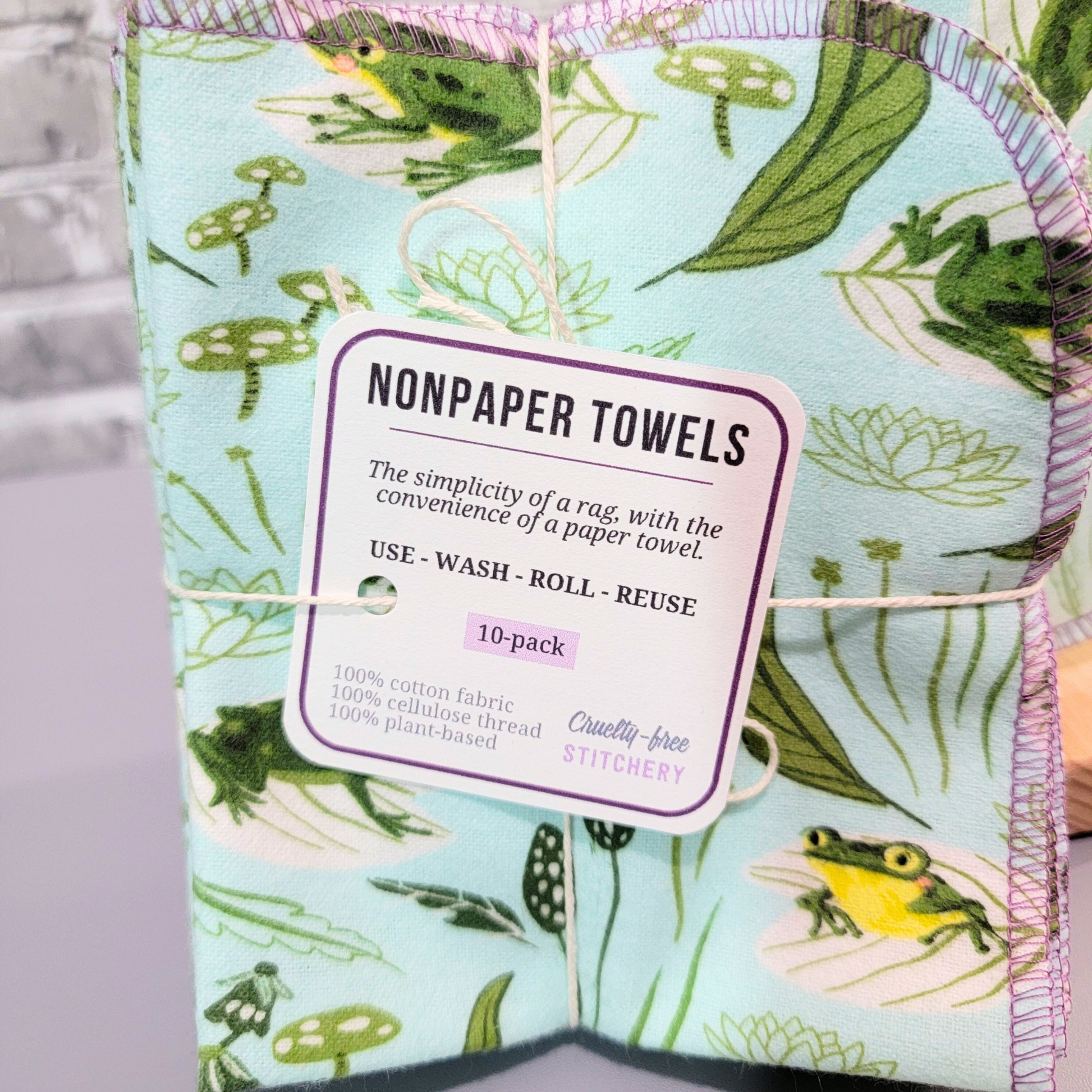 Close up of the NonPaper Towels tag. It says the simplicity of a rag with the convenience of a paper towel, use wash roll reuse, 10 pack, 100% cotton fabric, 100% cellulose thread, 100% plant based.