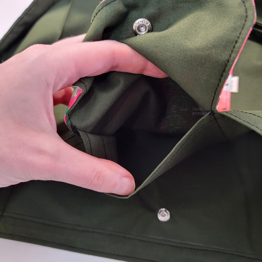 Inside of the foldable tote bag, a hidden pocket underneath the flap.