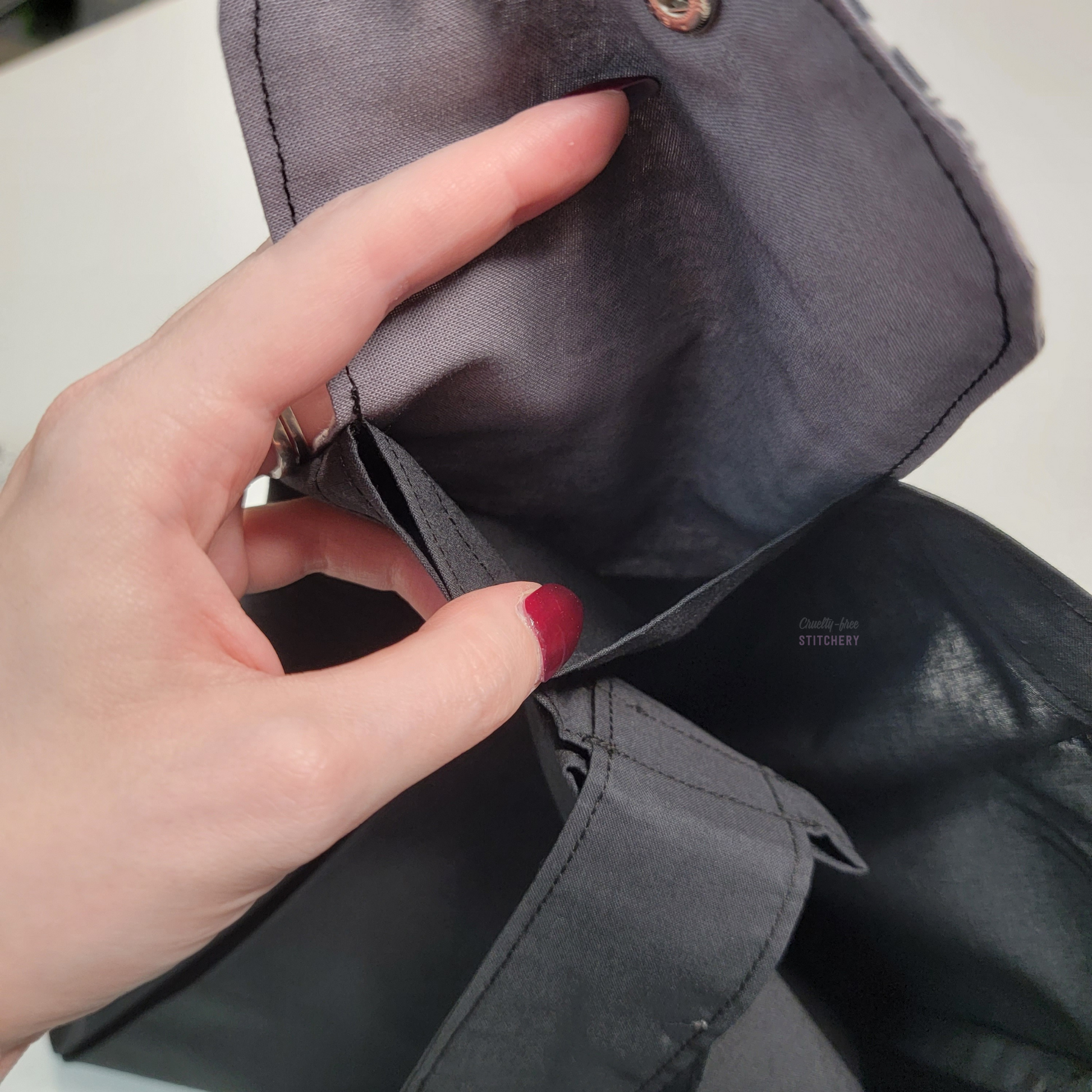 Inside of the foldable tote bag, a hidden pocket underneath the flap.