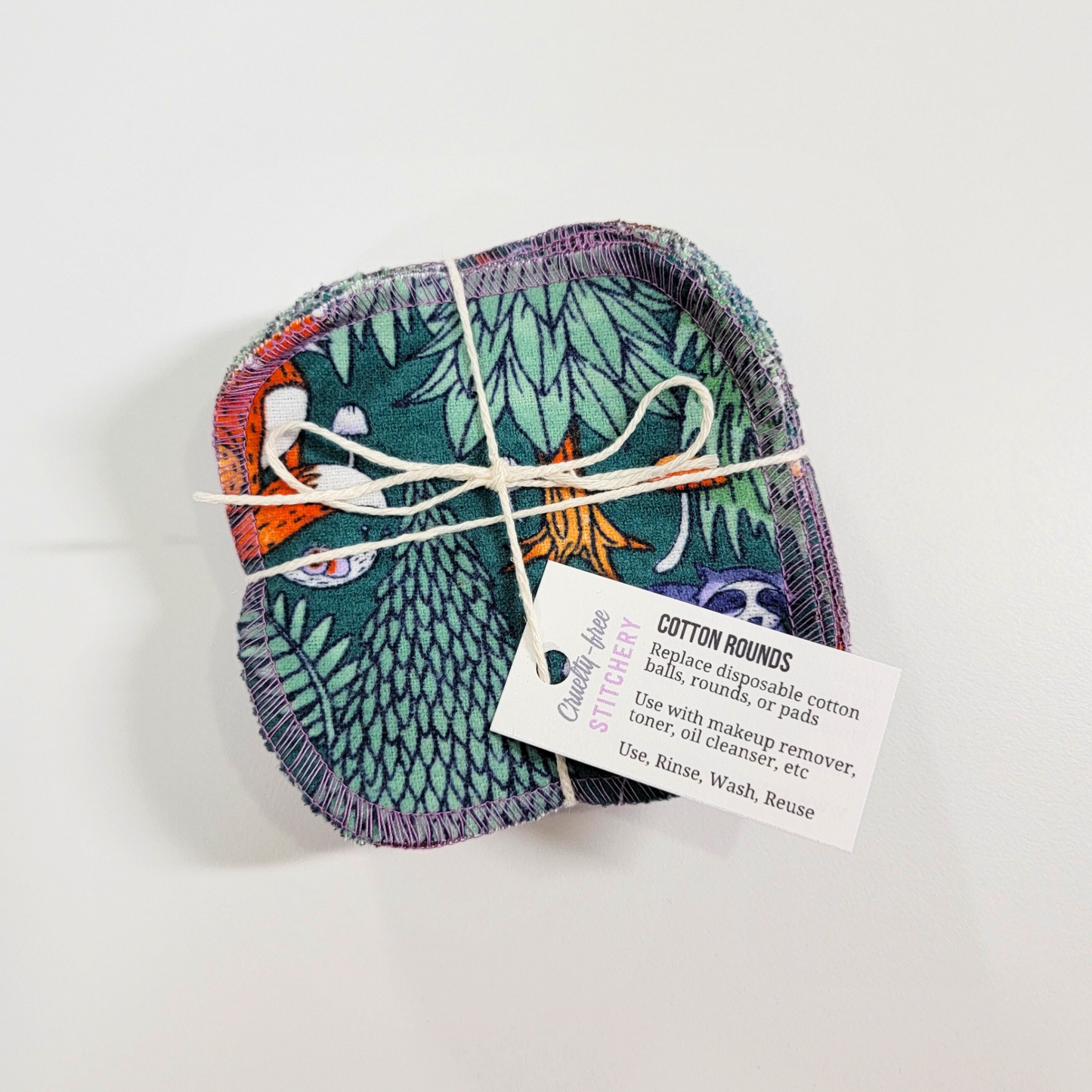 A bundled pack of the woodland print cotton rounds. They are tied together with a natural cotton string and a small white tag.
