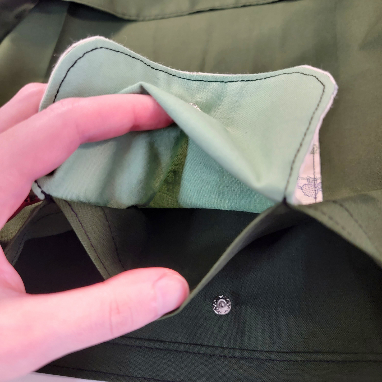 Inside of the foldable tote bag, a hidden pocket underneath the flap.