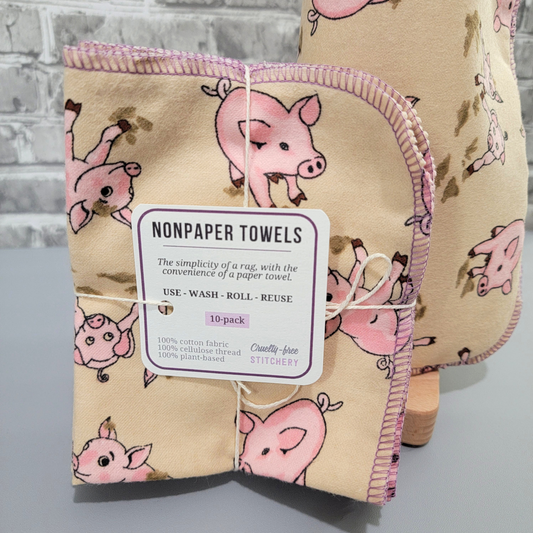 A bundled pack of the Tan Pigs NonPaper Towels, tied with string and a small paper tag. The simplicity of a rag with the convenience of a paper towel. Use wash roll reuse. 10 pack.