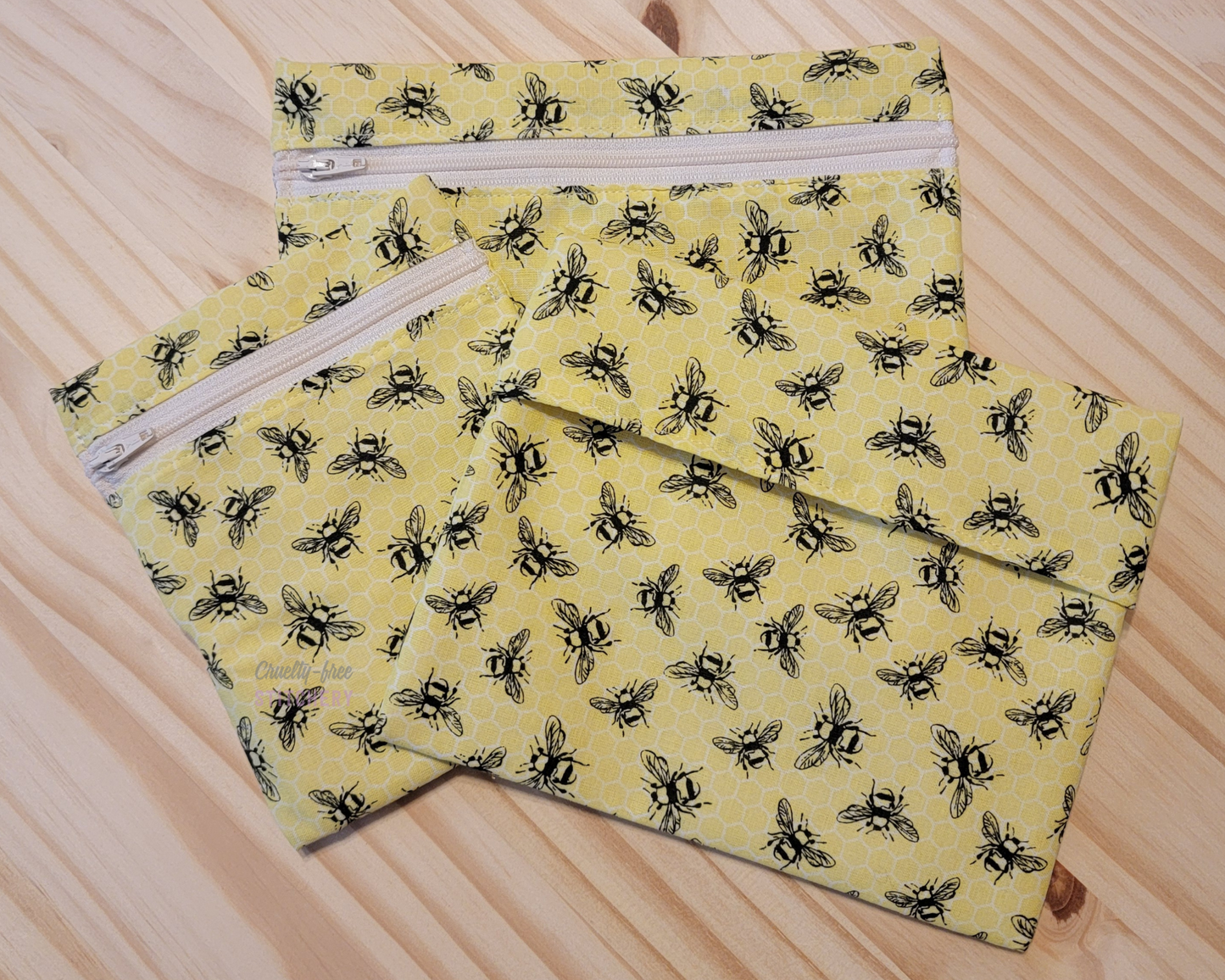 Three sizes of reusable snack bags in the yellow with black bees print.
Two sizes have zippers, which are an off-white color.