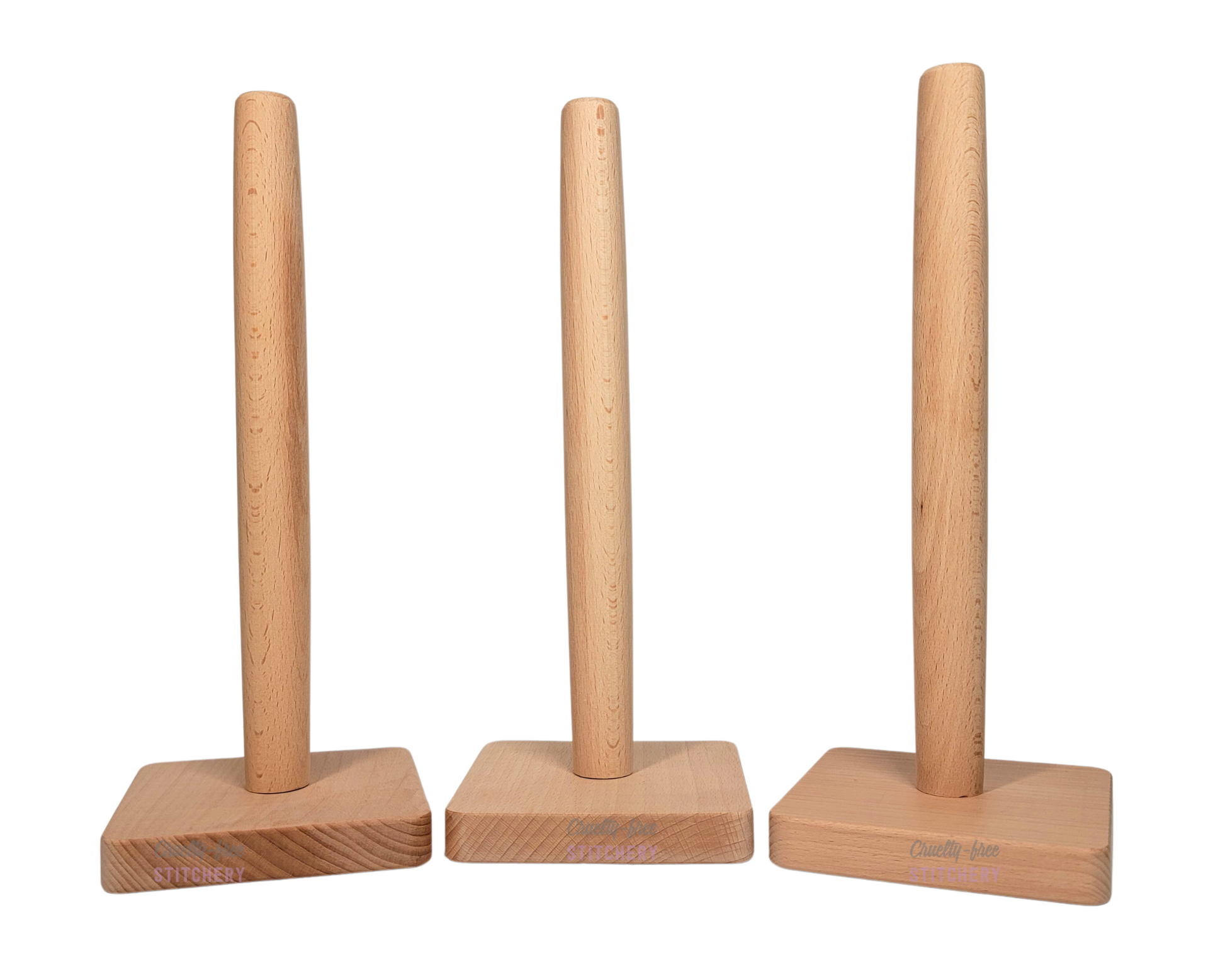 Three NonPaper Towel Holders, they are a light colored wood with a square base that has rounded corners, and a dowel in the center that is slightly wider in the middle of its length.