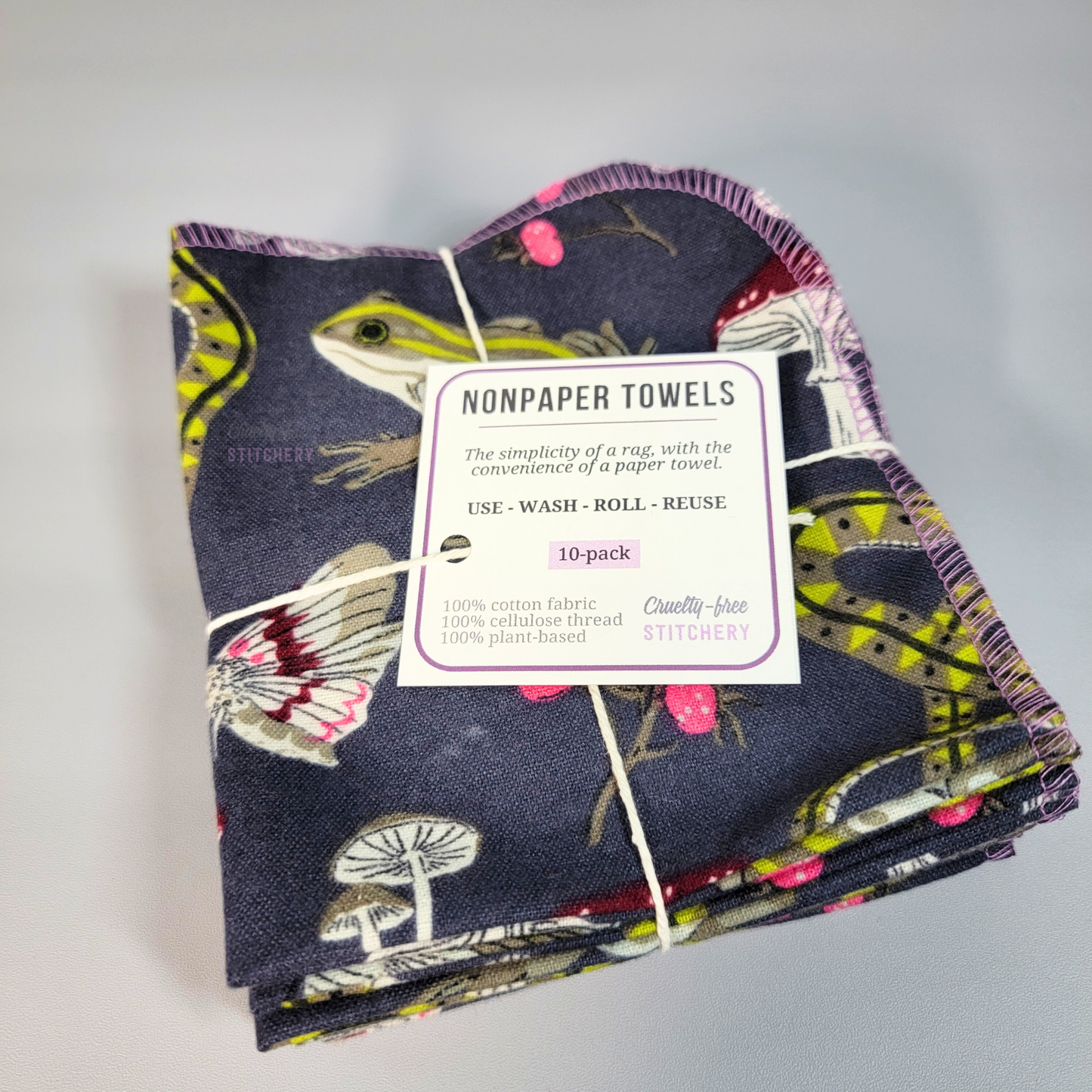 A bundled pack of the NonPaper Towels. Tied with string like a gift and a small paper tag. The tag says "NonPaper Towels, the simplicity of a rag with the convenience of a paper towel, use wash roll reuse."