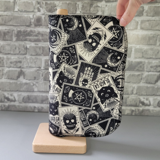 The tarot cards print nonpaper towels on the same wooden holder, with my hand reaching in as if pulling one from the top corner. The towel is a rounded rectangle and stitched with black thread.