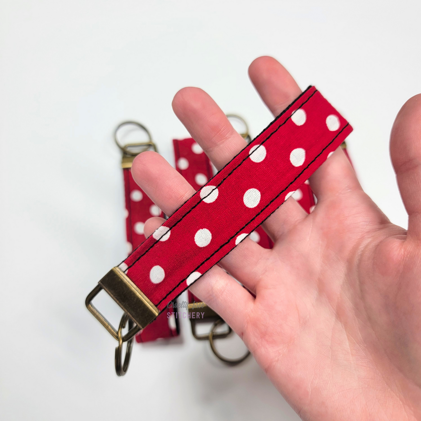 Holding a key fob with my hand through the strap.