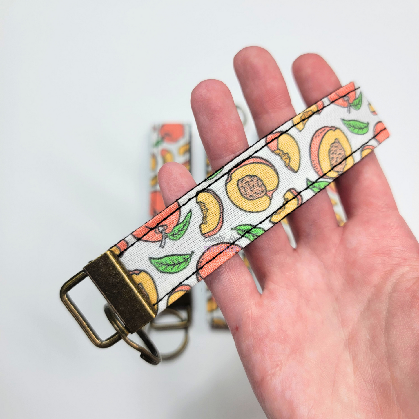 Holding a key fob with my hand through the strap.