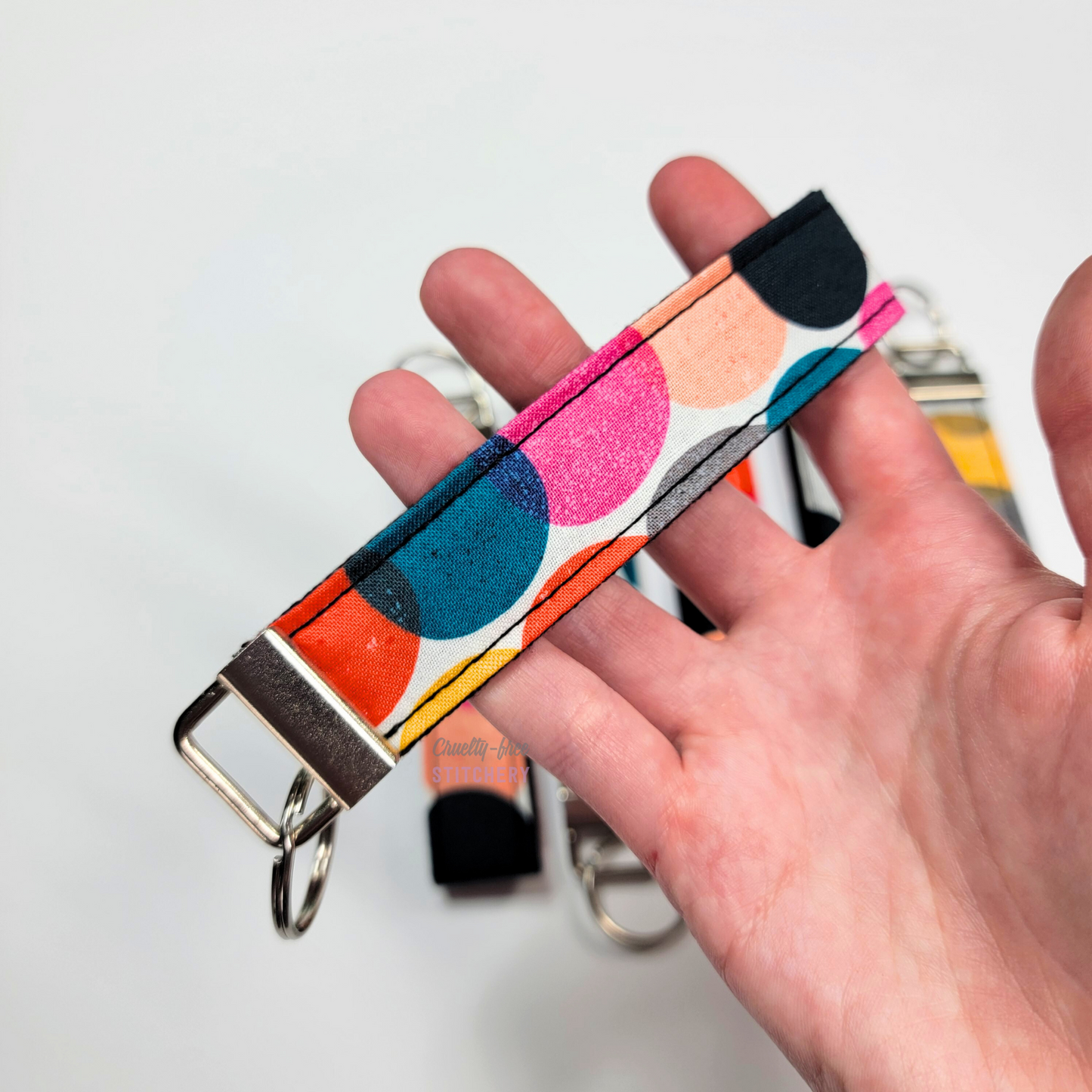 Holding a key fob with my hand through the strap.
