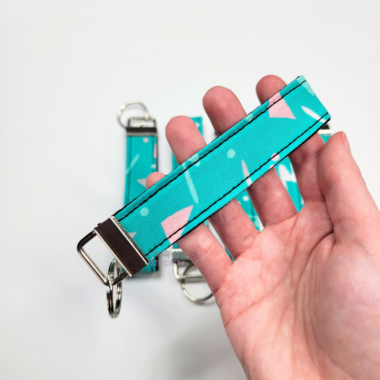 Holding a key fob with my hand through the strap.