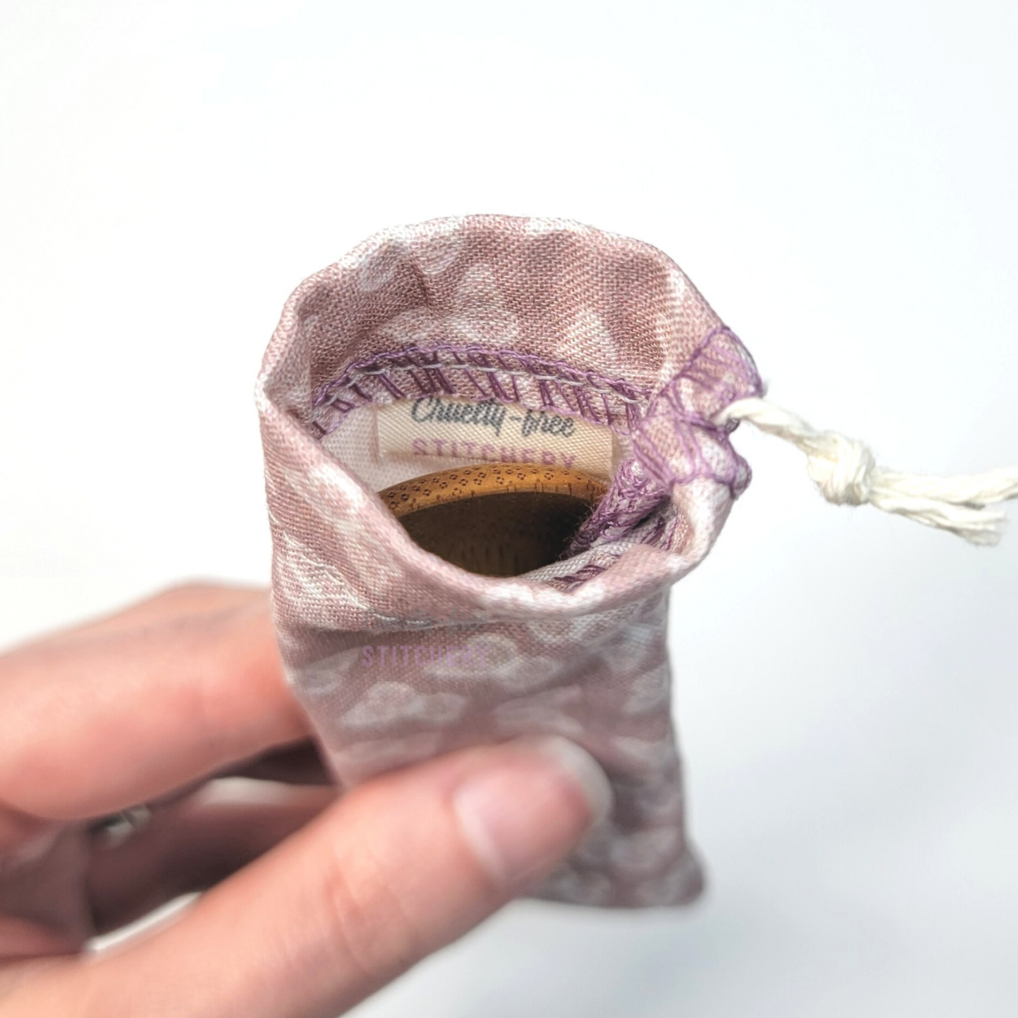 A reusable spork pouch, viewed from the top down. Inside the pouch is a tag with the Cruelty-Free Stitchery logo.