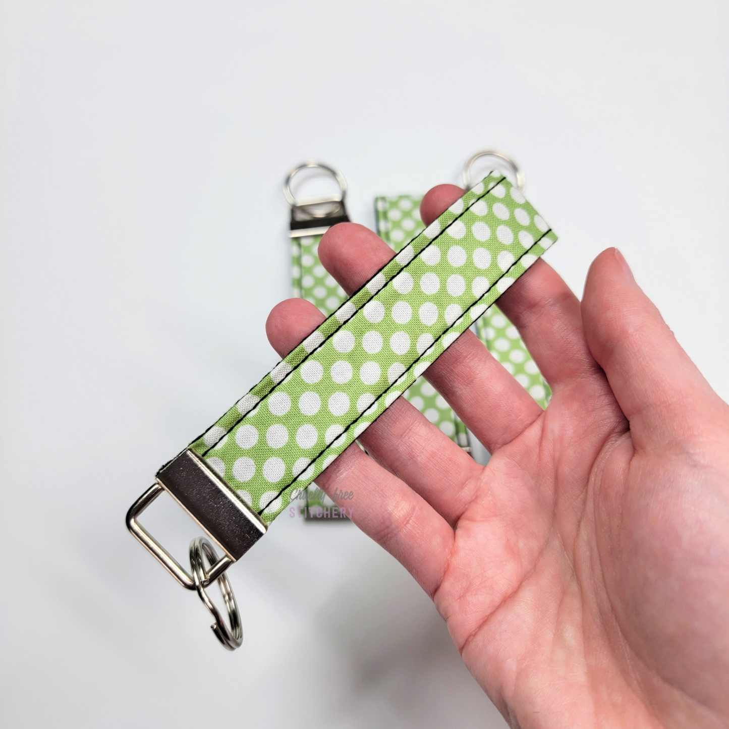 Holding a key fob with my hand through the strap.