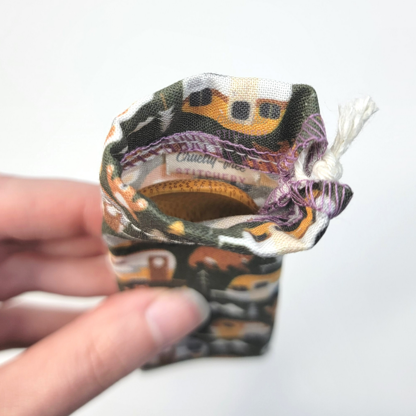 A reusable spork pouch, viewed from the top down. Inside the pouch is a tag with the Cruelty-Free Stitchery logo.