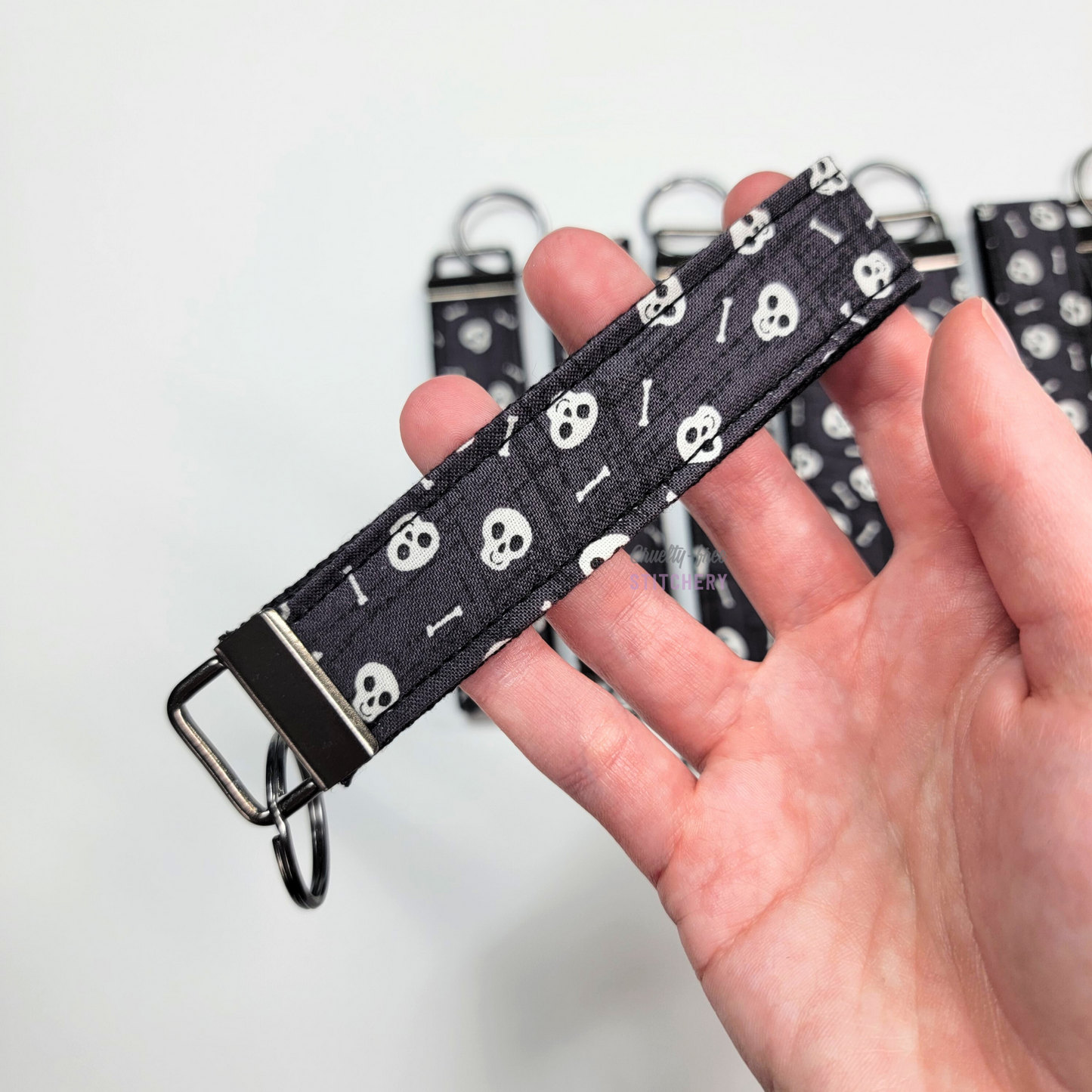 Holding a key fob with my hand through the strap.
