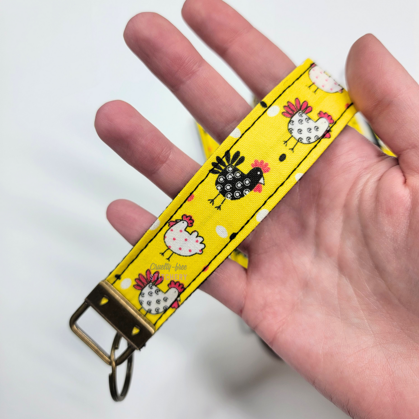 Holding a key fob with my hand through the strap.
