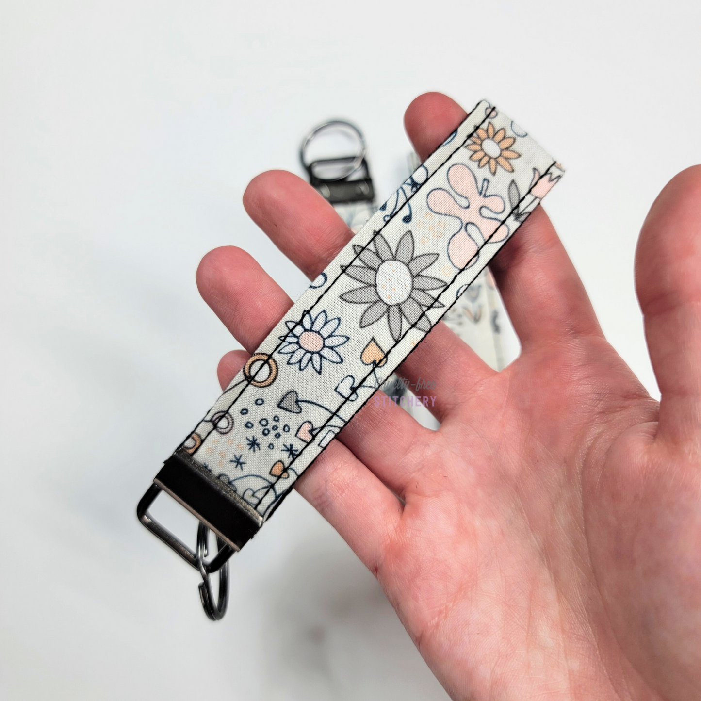 Holding a key fob with my hand through the strap.