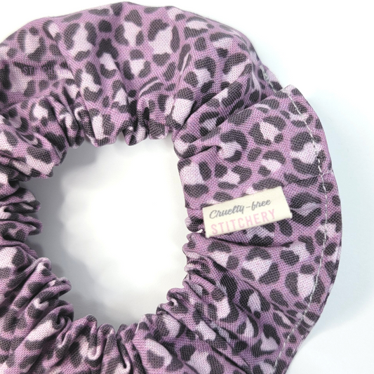 Close-up of the scrunchie with a small white tag with the Cruelty-Free Stitchery logo.