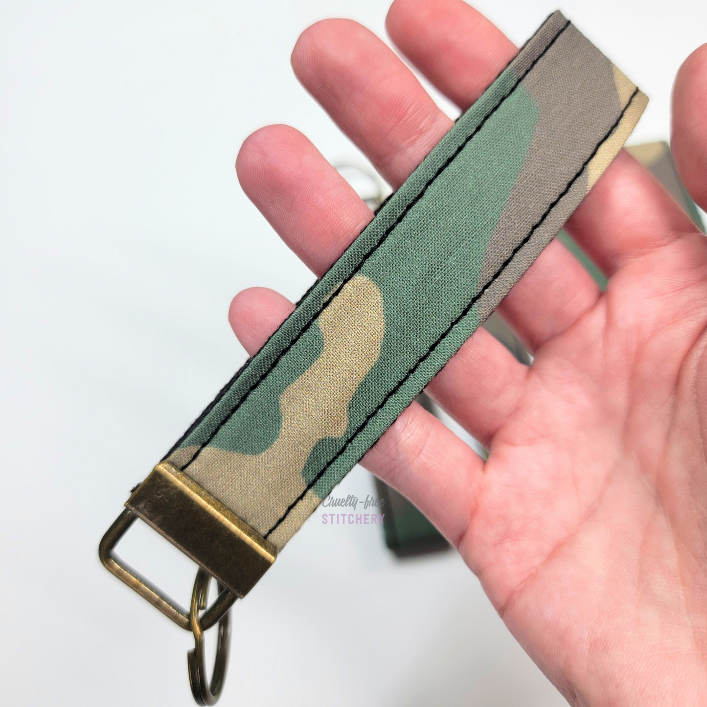 Holding a key fob with my hand through the strap.