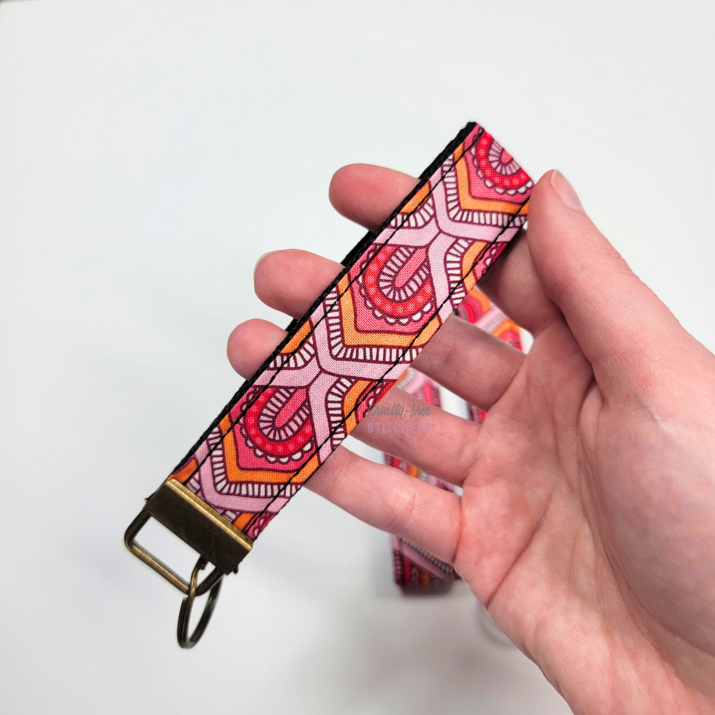 Holding a key fob with my hand through the strap.