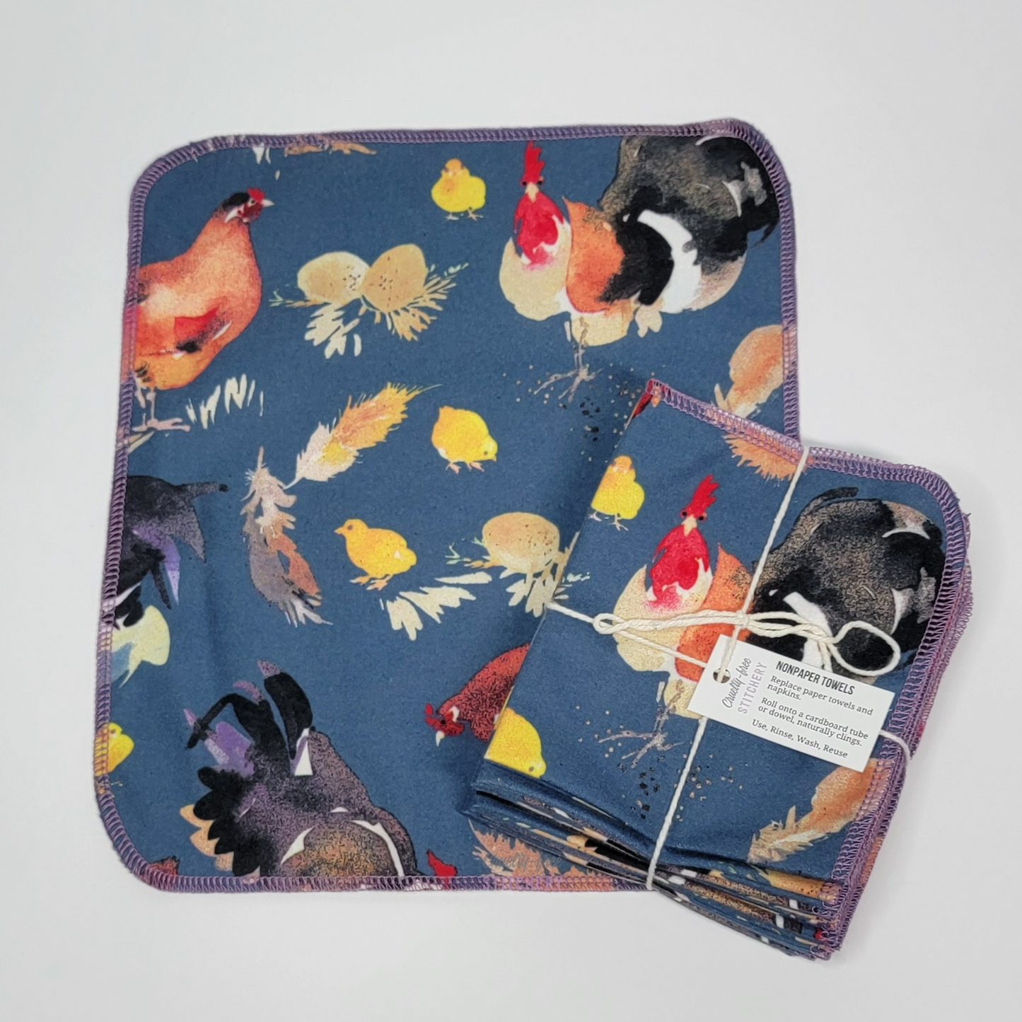 A Bue Chickens NonPaper Towel laid flat with a bundled pack placed on top. The bundled pack is tied with string and a small white paper tag.