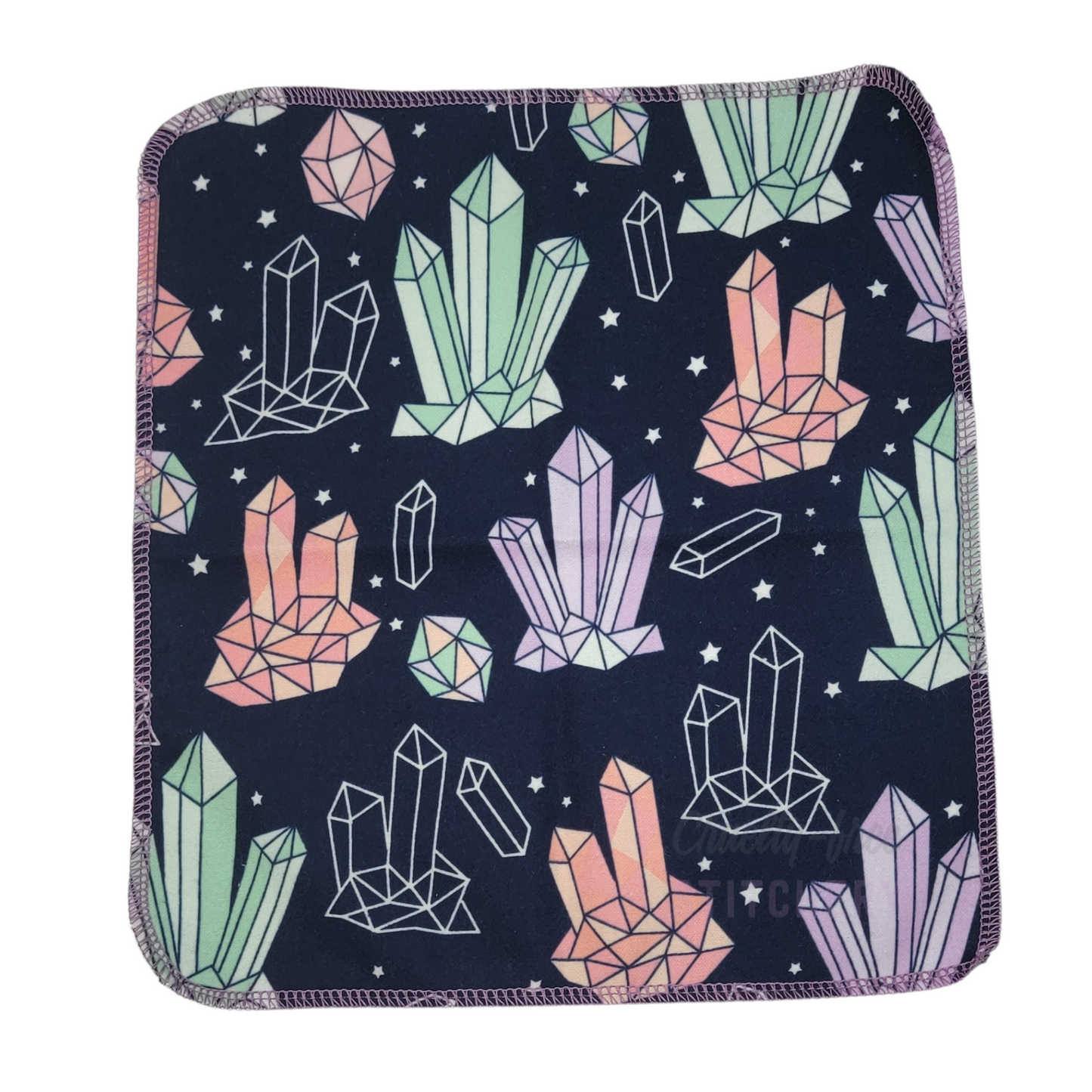 A full photo of a crystals print NonPaper Towel. The edges are rounded and stitched in a lilac purple thread.