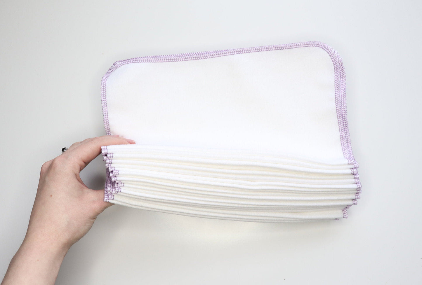 Stack of folded white NonPaper Towels.