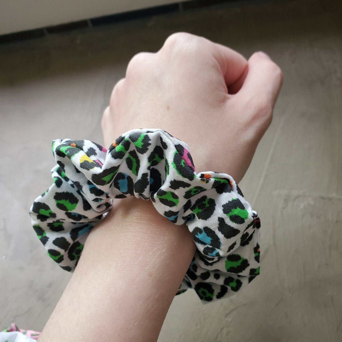 Scrunchie shown on my wrist for size reference. Fabric sticks out about an inch from the center of the scrunchie.