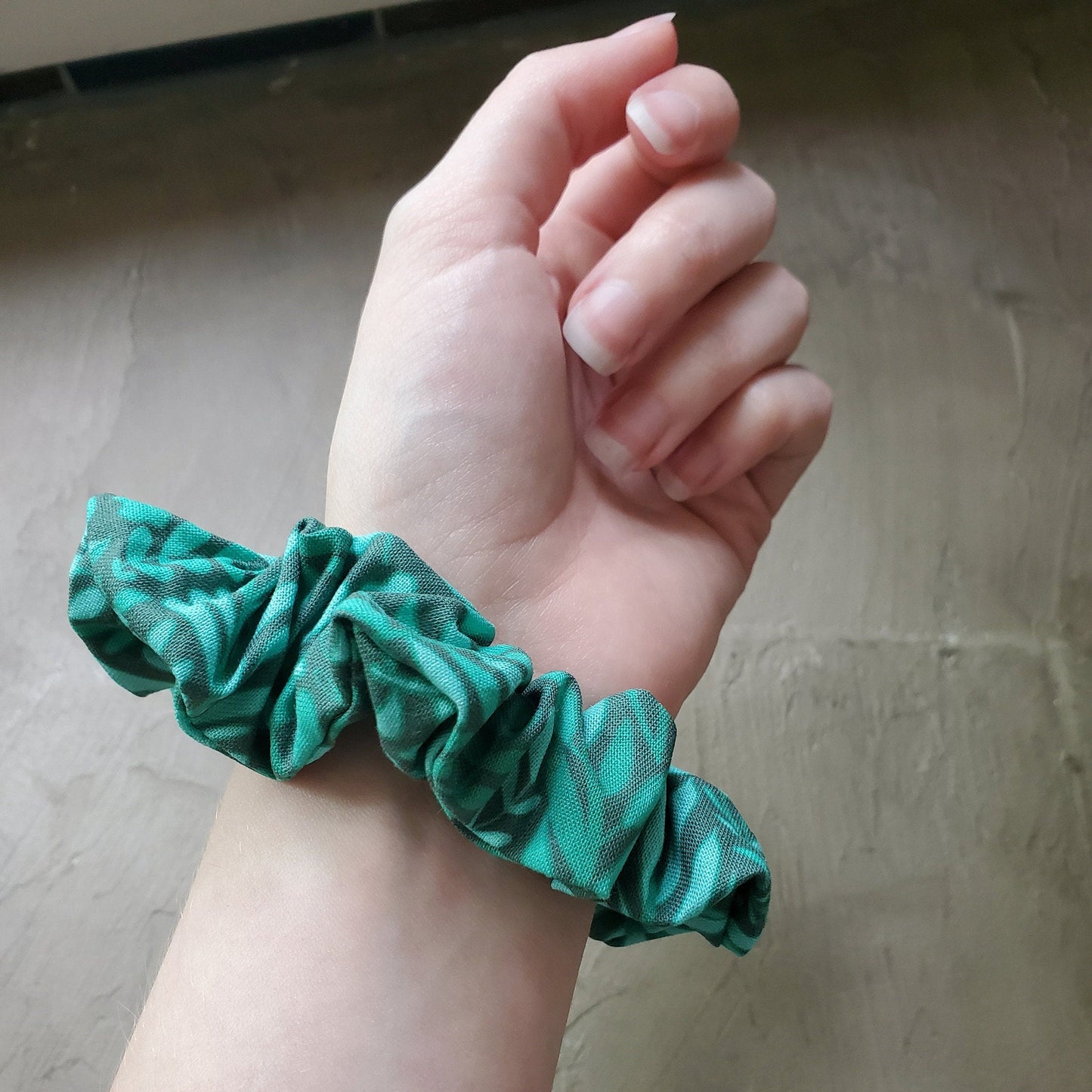 Scrunchie shown on my wrist for size reference. Fabric sticks out about an inch from the center of the scrunchie.