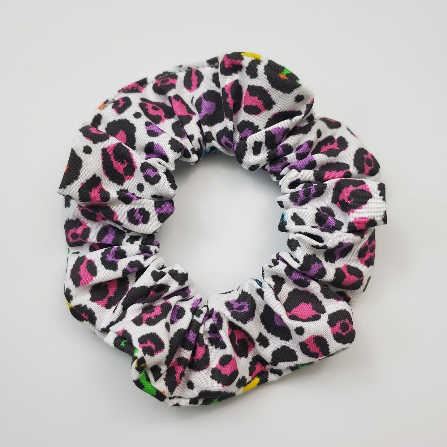 Scrunchie with rainbow cheetah print on a white background.