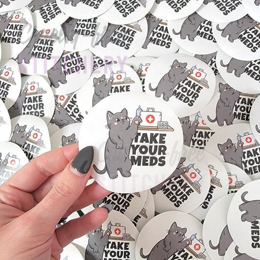 Round "take your meds" sticker in my hand to show the size. It is 3 inches wide.