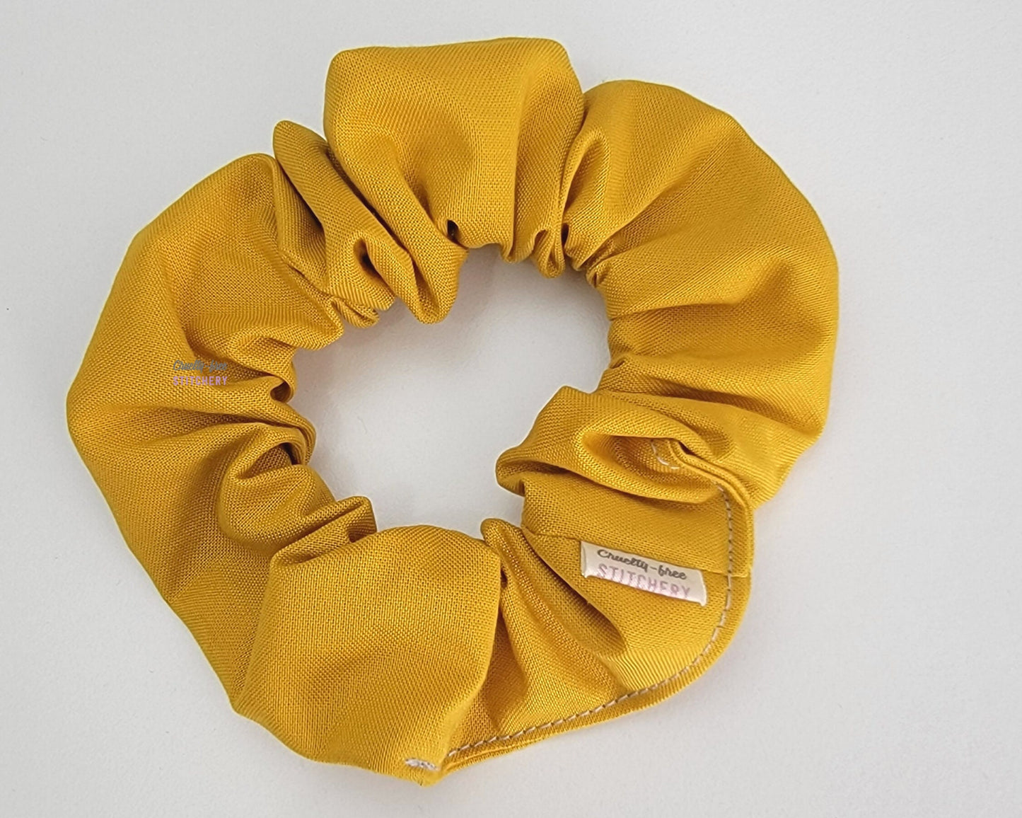 Solid mustard yellow scrunchie.
