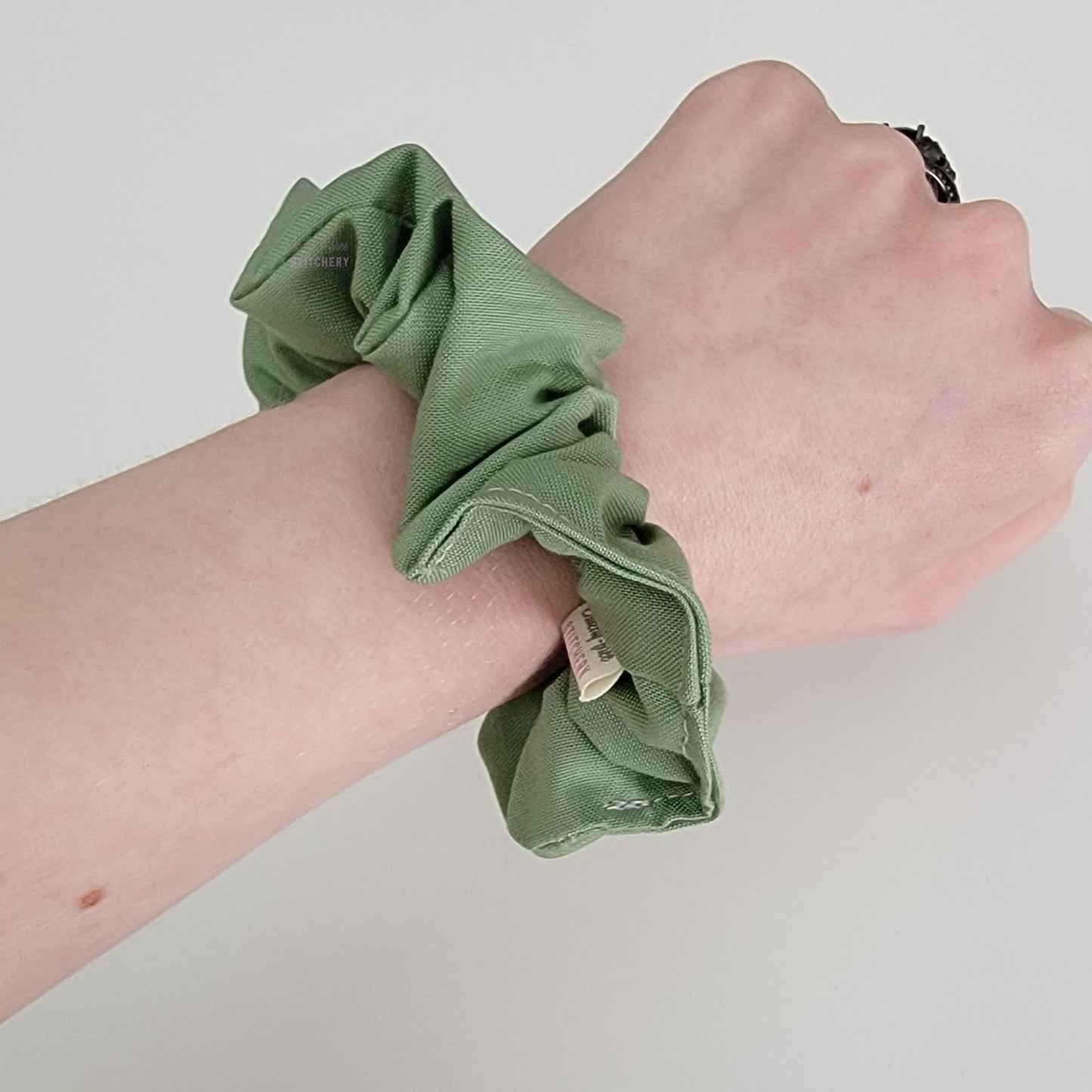Scrunchie shown on my wrist for size reference. Fabric sticks out about an inch from the center of the scrunchie.