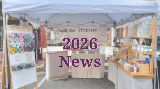 2026 News, text with a background image of my market booth. Scrunchies on a pegboard on the left, a Cruelty-Free Stitchery banner and two small tables in the middle, and on the left is a wooden table with shelves full of NonPaper Towels.