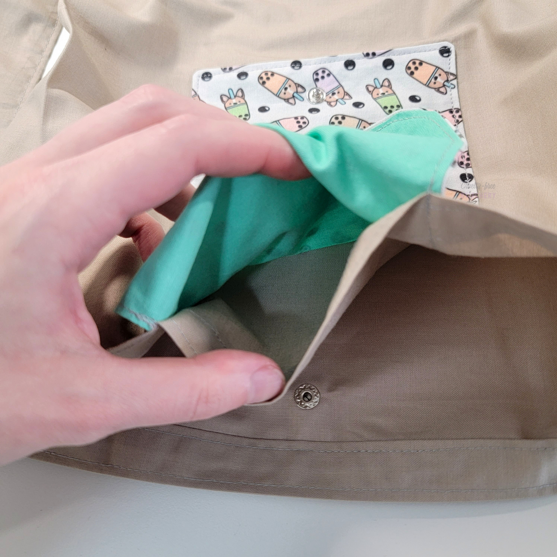 Inside of the foldable tote bag, a hidden pocket underneath the flap.