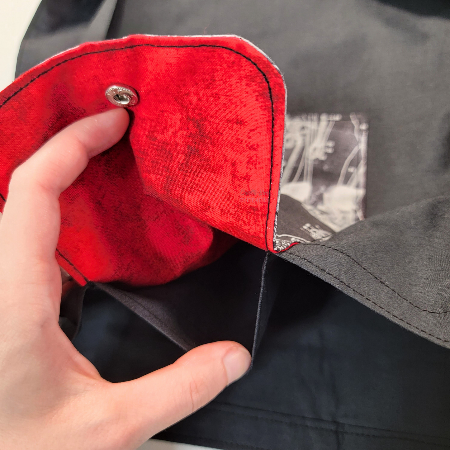 Inside of the foldable tote bag, a hidden pocket underneath the flap. This one has a bright distressed red inside the flap, but the color may vary.