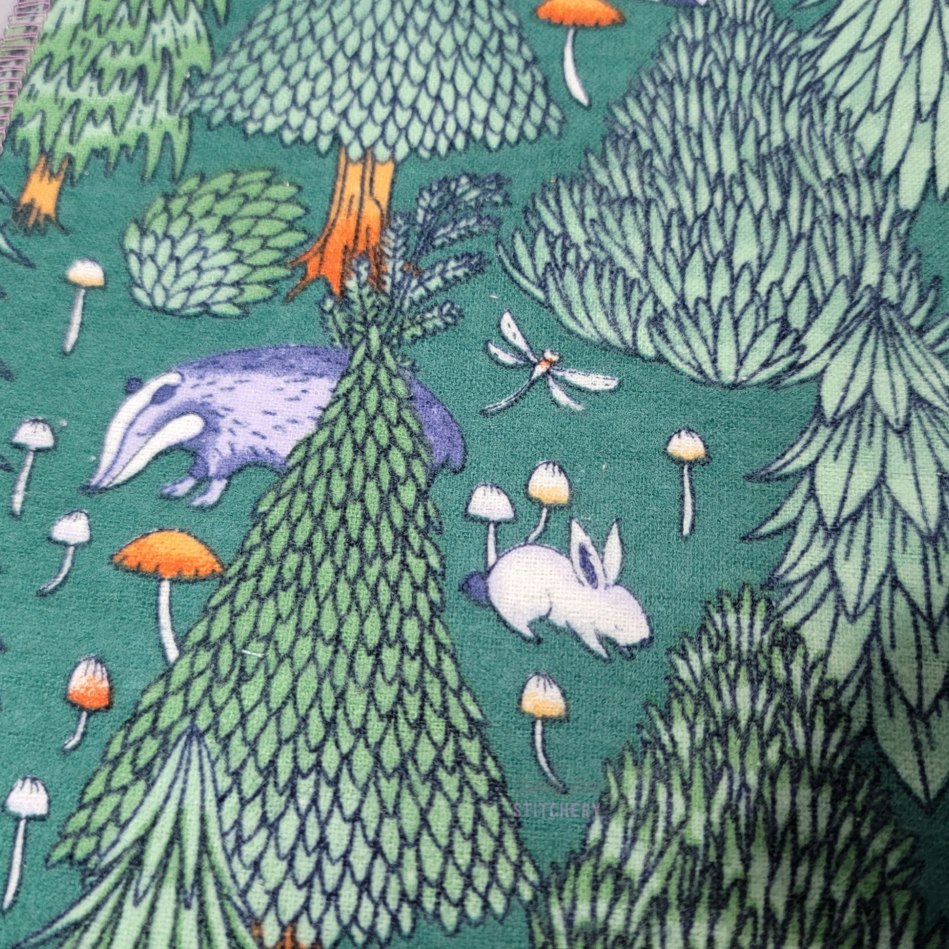 Close-up of the print, showing a badger, rabbit, and dragonfly.