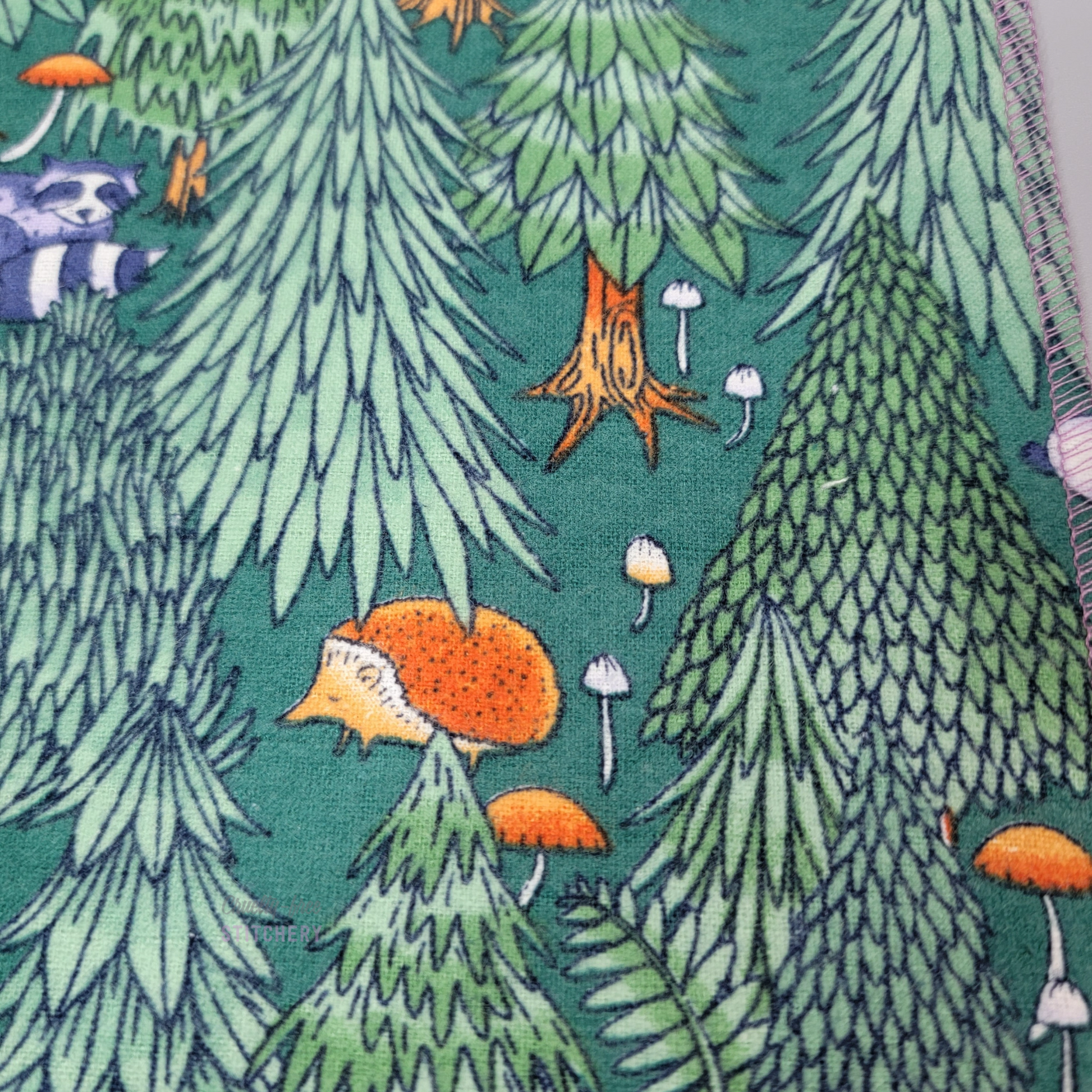 Close-up of the print, showing a raccoon and hedgehog.