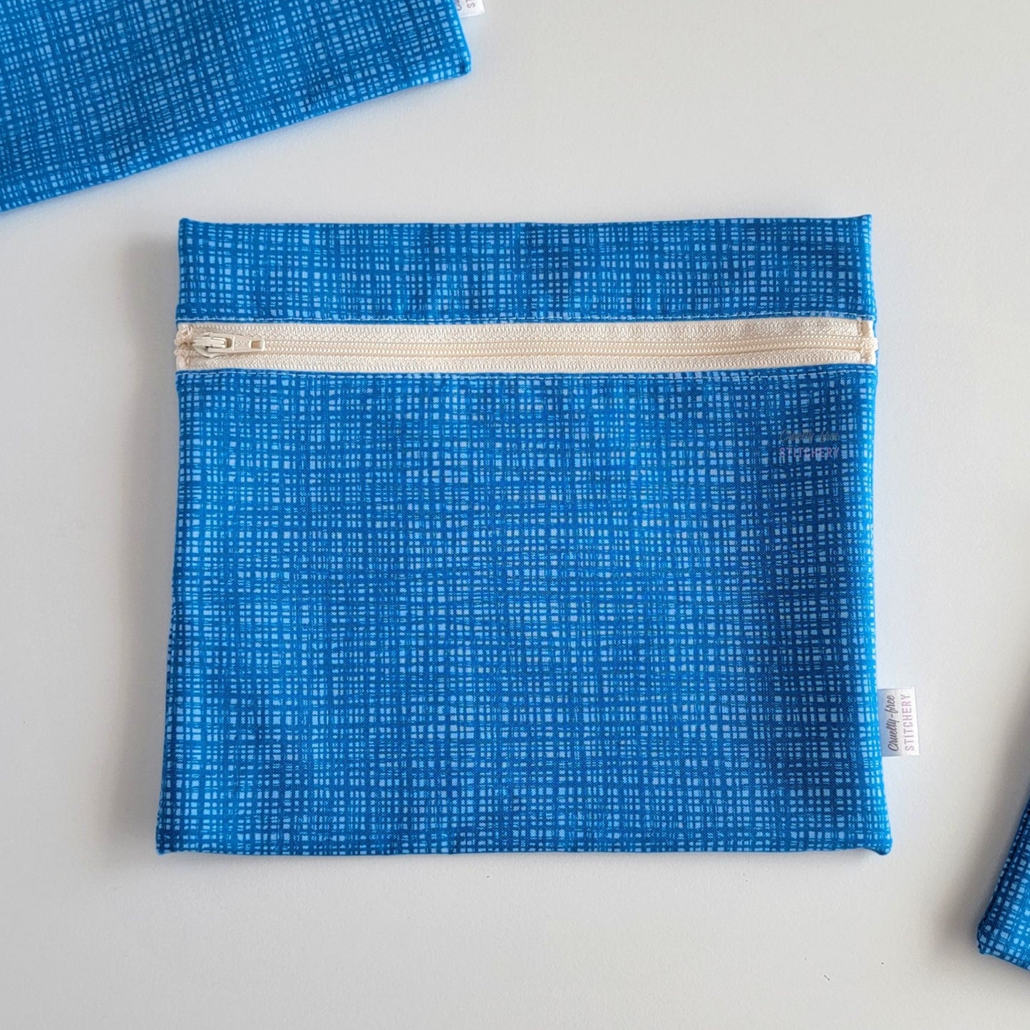 The Blue Texture Large Zip Reusable Snack Bag, shown closed with two other bags barely visible on the edges of the photo. 