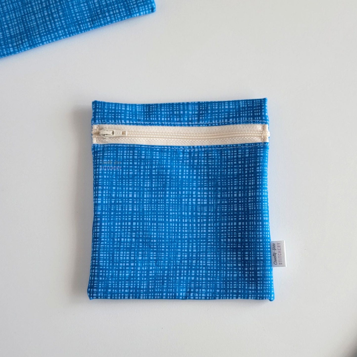 The Blue Texture Small Zip Reusable Snack Bag, shown closed with two other bags barely visible on the edges of the photo. 
