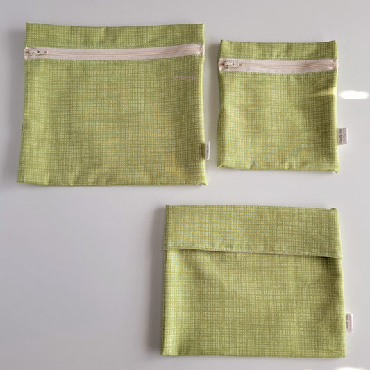 Three Light Green Texture Reusable Snack Bags arranged separately to show the difference between sizes. Large Zip is not quite double the size of the Small Zip, and the Foldover is slightly smaller than the Large Zip.