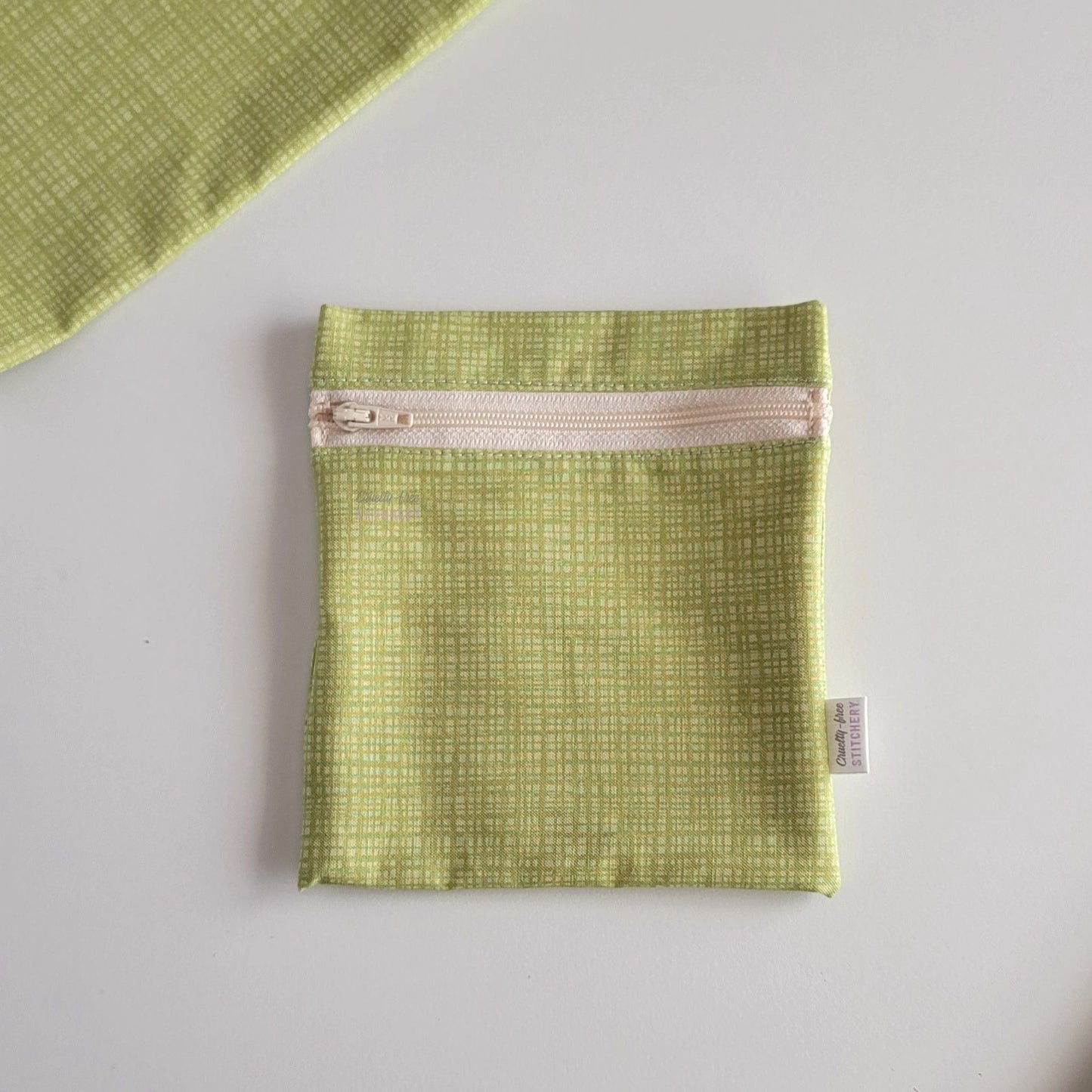 The light green texture Small Zip Reusable Snack Bag, shown closed with two other bags barely visible on the edges of the photo. 