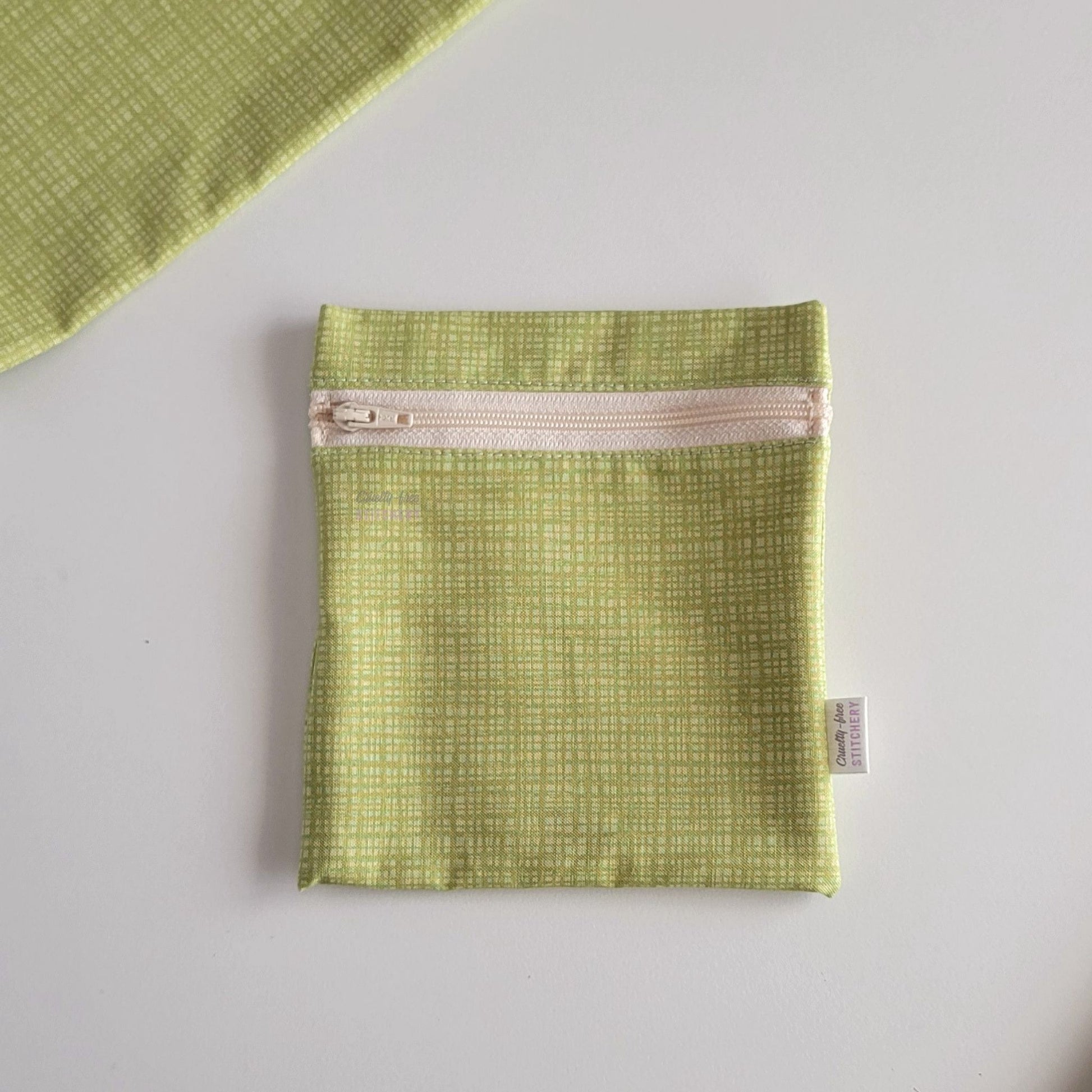 The light green texture Small Zip Reusable Snack Bag, shown closed with two other bags barely visible on the edges of the photo. 