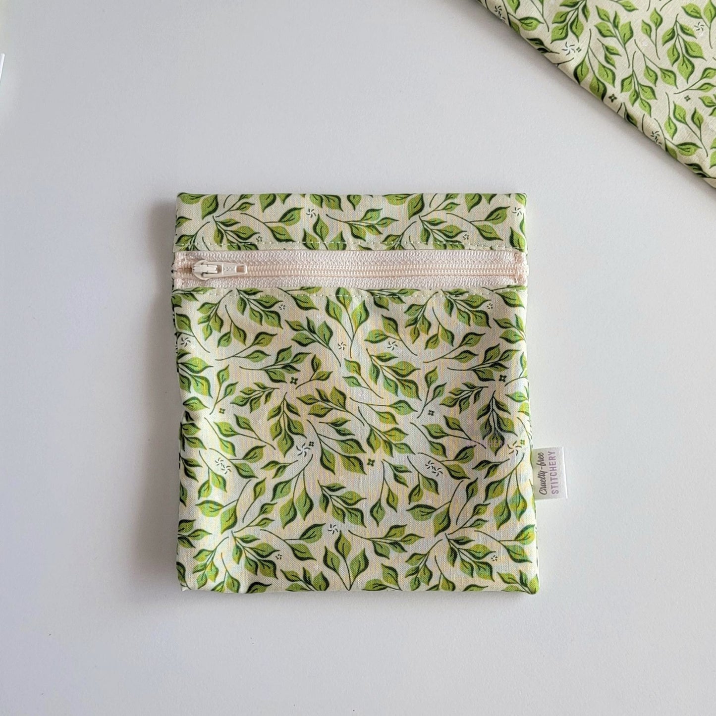 The Olive Leaves Small Zip Reusable Snack Bag, shown closed with two other bags barely visible on the edges of the photo. 
