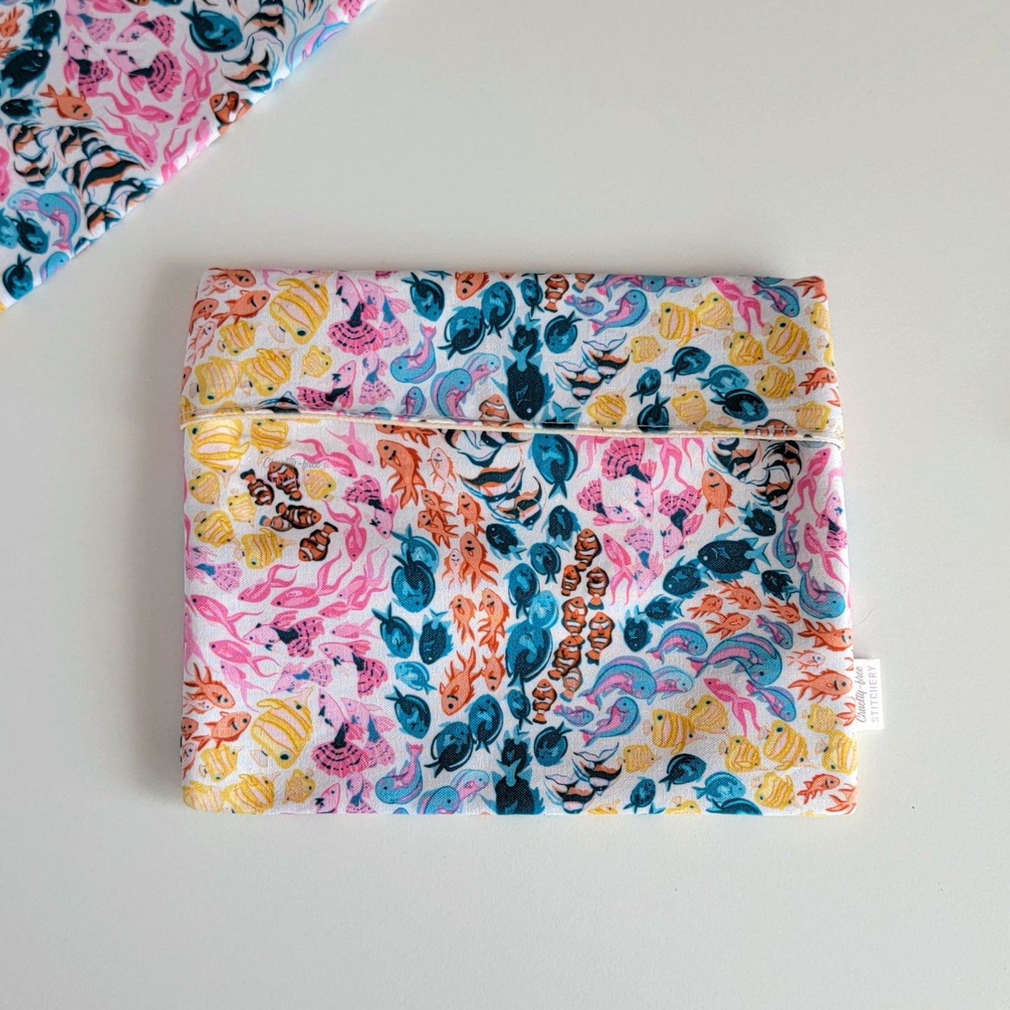 The colorful reef Foldover Reusable Snack Bag, shown closed with two other bags barely visible on the edges of the photo. 
