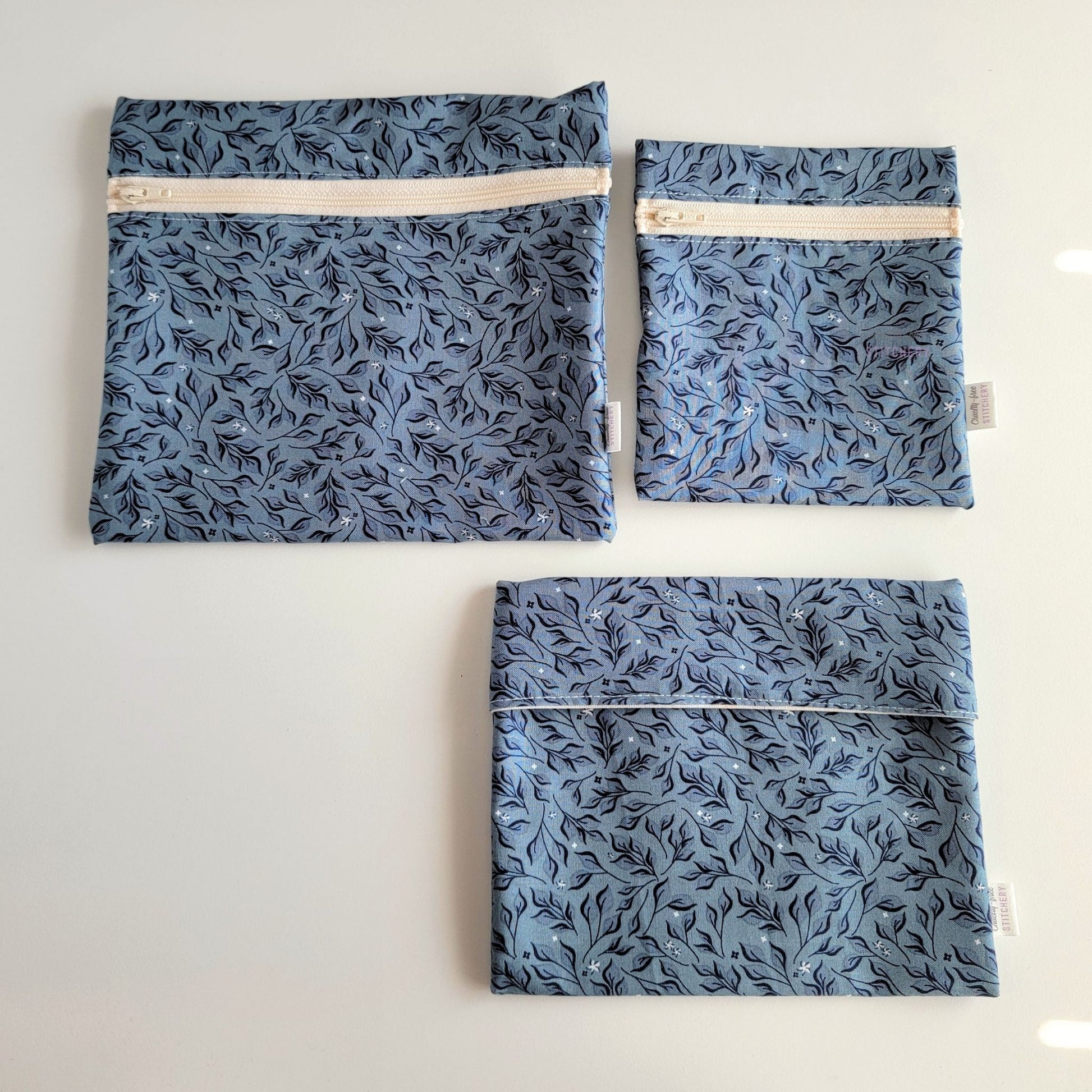 Three Stone Leaves Reusable Snack Bags arranged separately to show the difference between sizes. Large Zip is not quite double the size of the Small Zip, and the Foldover is slightly smaller than the Large Zip.
