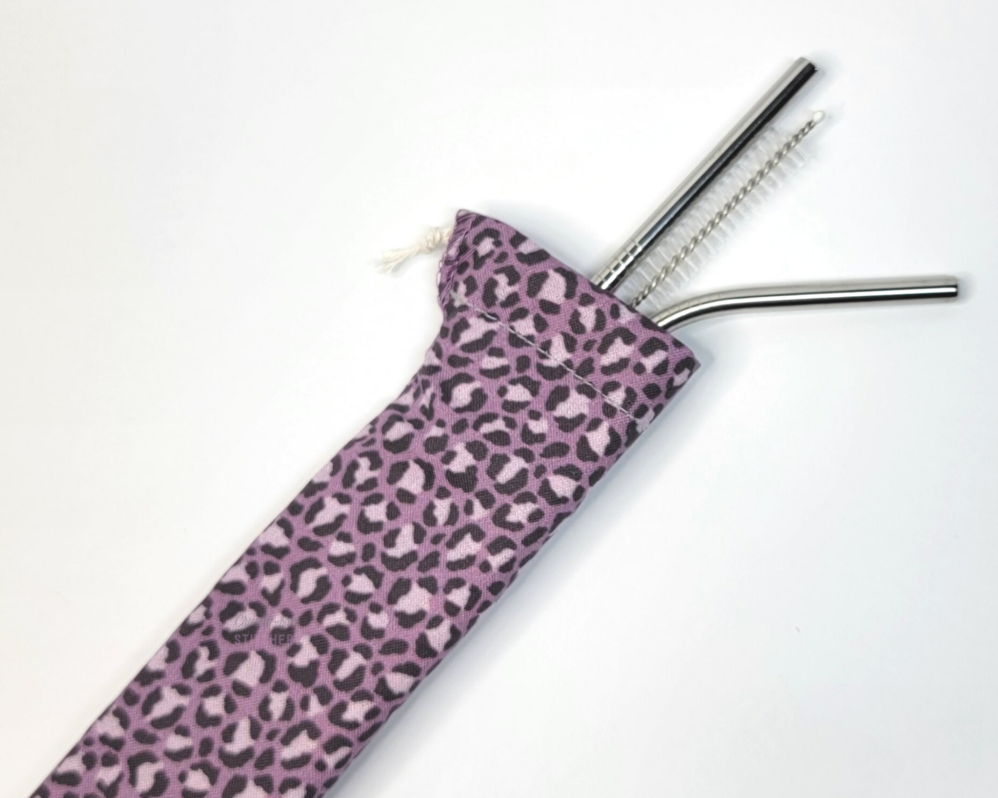 Reusable straw pouch with stainless steel straws sticking out the top. The fabric of the pouch is a muted violet purple leopard print and it has a drawstring closure.