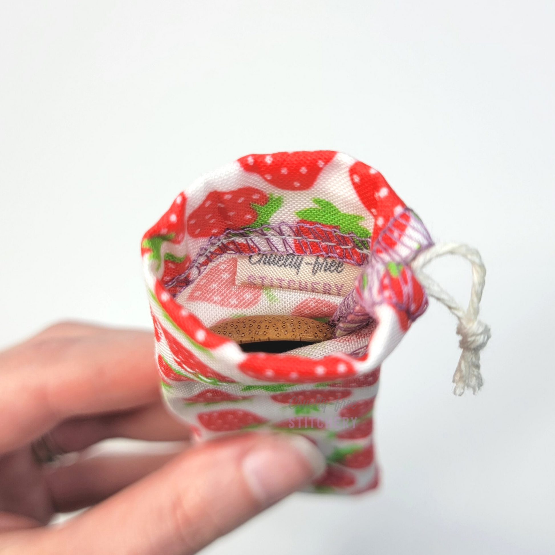 A reusable spork pouch, viewed from the top down. Inside the pouch is a tag with the Cruelty-Free Stitchery logo.