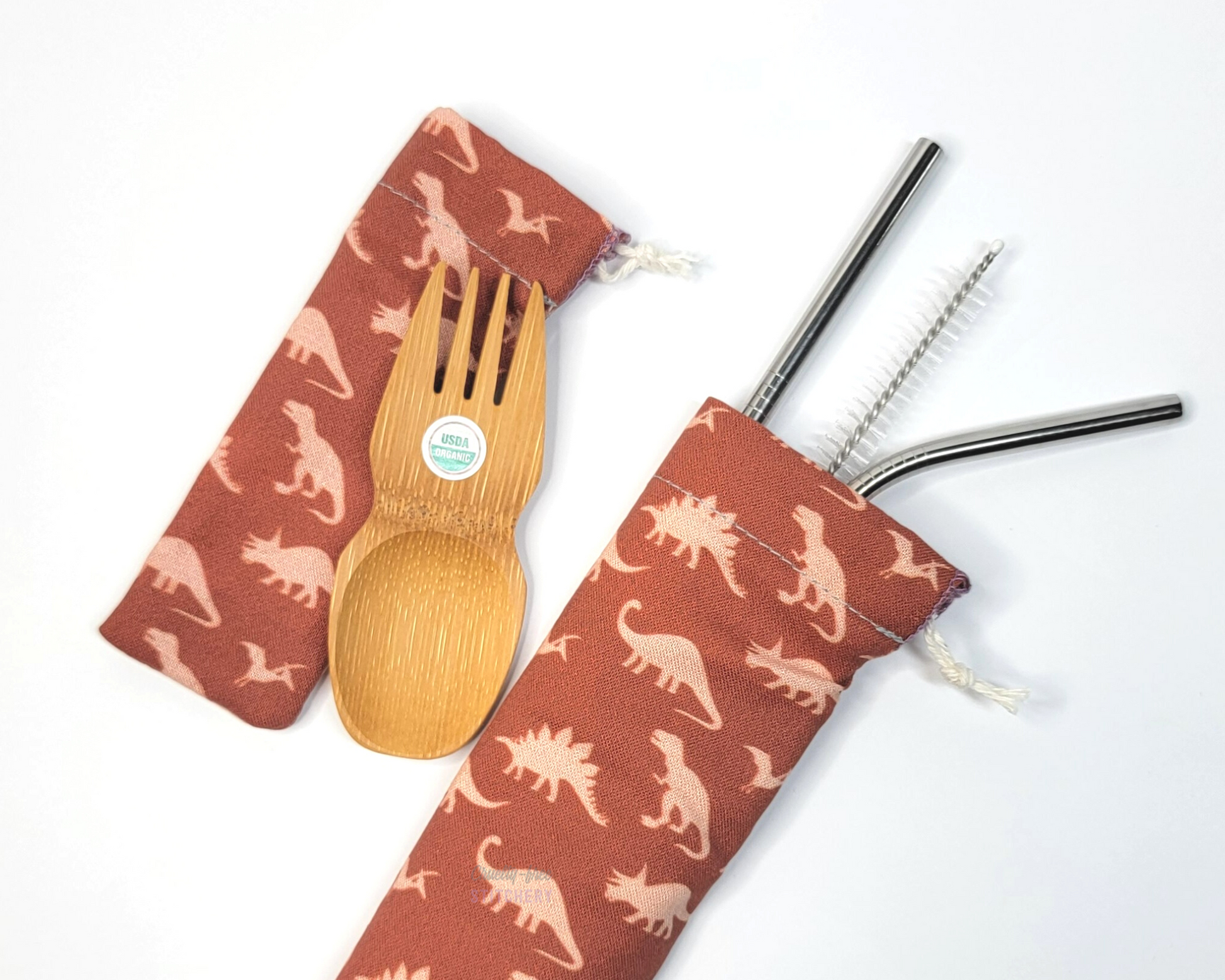 Reusable bamboo spork and stainless steel straw pouch set. The pouches are both dark orange with light orange dinosaurs.