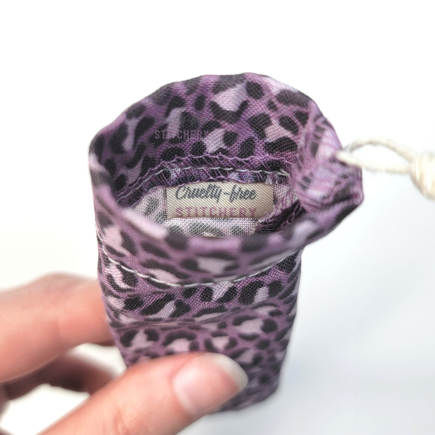 A reusable spork pouch, viewed from the top down. Inside the pouch is a tag with the Cruelty-Free Stitchery logo.